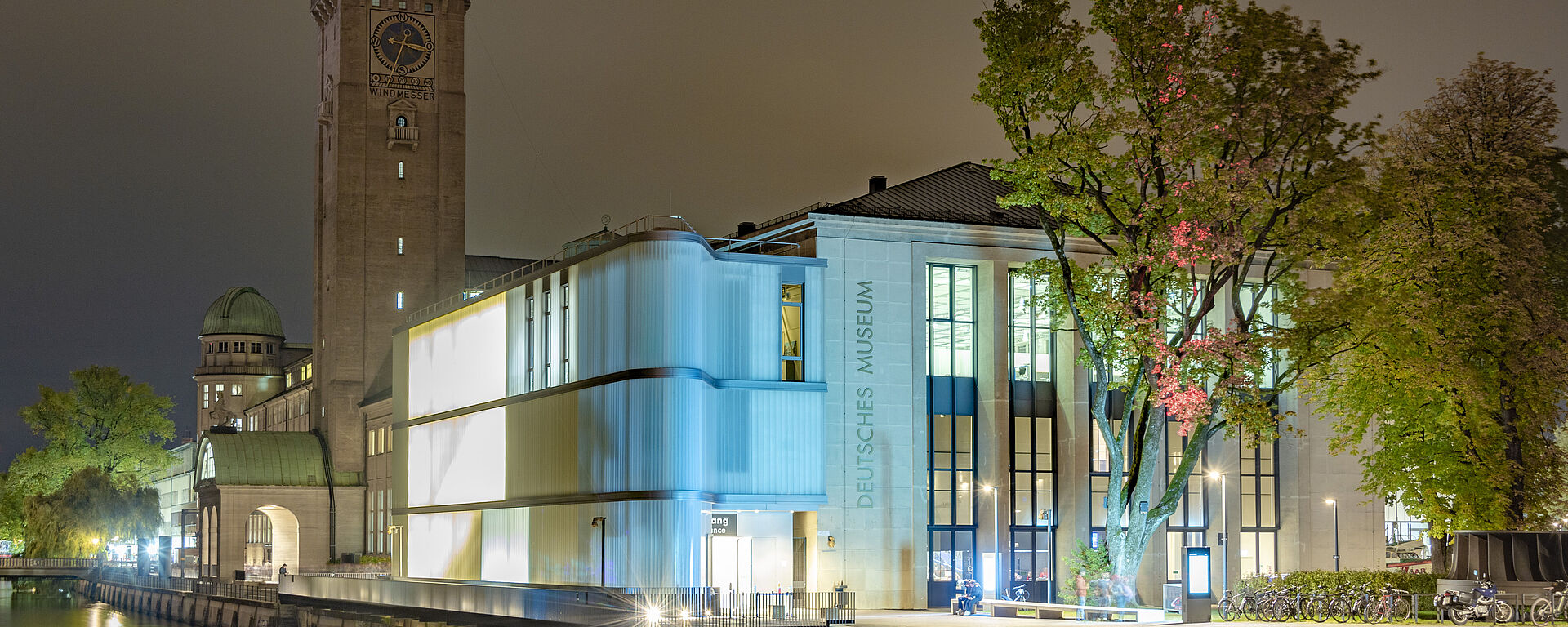Nachtaufnahme des Deutschen Museums, mit Museumsturm und Eingangsbereich.