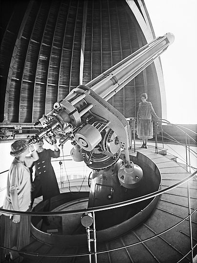 Eine Frau schaut durch den Refraktor von Carl Zeiss von 1925 mit 300 mm Öffnung in der Westkuppel des Deutschen Museums (vor 1945).