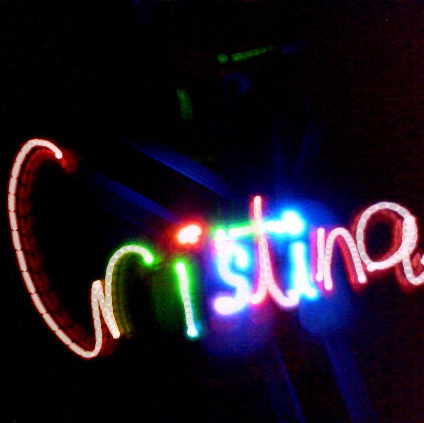 Lichtkunst-Werkstatt Leuchtender Schriftzug "Christina". Dieser wurde mit verschieden farbigen Lichtquellen in einen dunklen Raum gemalt.