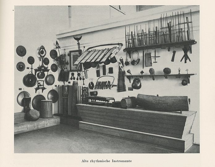 Historisches Foto: "Alte rhythmische Instrumente" in der Ausstellung Musikinstrumente von 1925. Tatsächlich handelt es sich durchwegs um zeitgenössische Instrumente außereuropäischer Kulturen, viele davon mit kolonialer Provenienz.