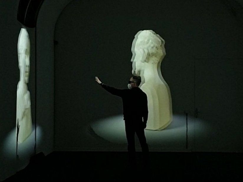 Mann mit VR-Brille greift nach 3D-Modellen