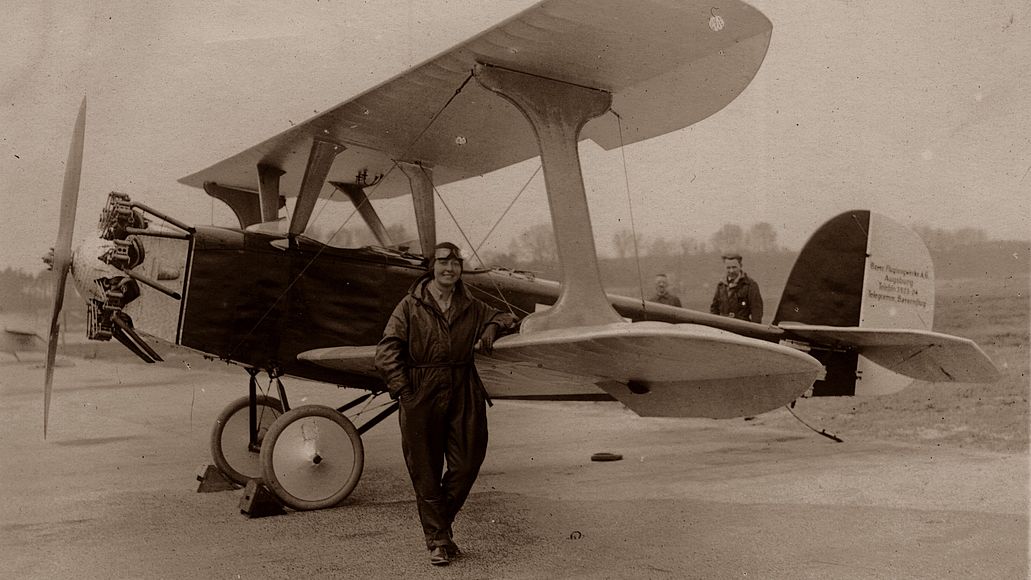 Eine alte Fotografie zeigt die Pilotin Thea Rasche vor einem Udet U 12 Flamingo im Jahr 1926.
