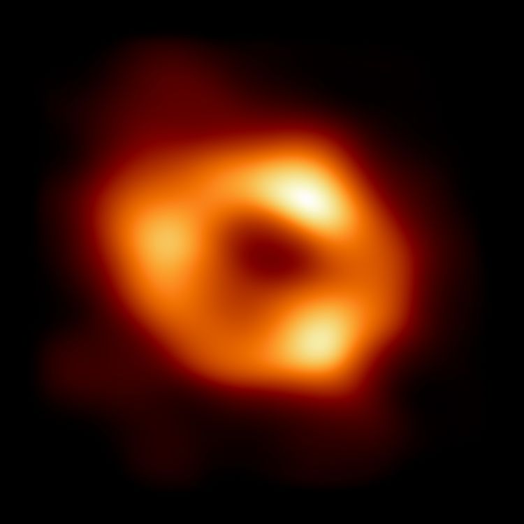 This is the first image of Sgr A*, the supermassive black hole at the centre of our galaxy, with an added black background to fit wider screens. 