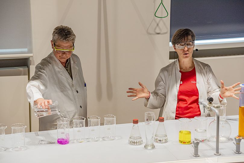 Vorführung mit Experimenten im Hörsaal Chemie. Flüssigkeiten verfärben sich.