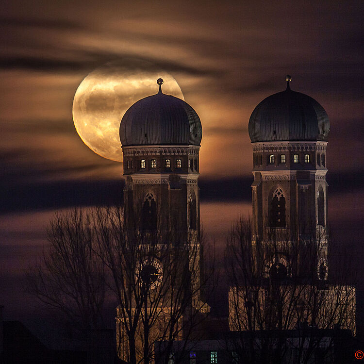 Vollmond hinter den zwei Türmen der Frauenkirche.