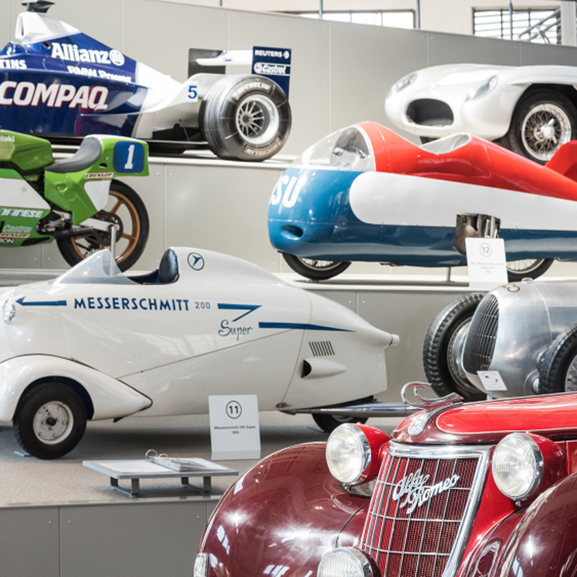 Blick auf die Stufen mit Motorfahrzeugen in Halle III, darunter der aerodynamisch verkleidete Kabinenroller Messerschmitt KR Super 200 von 1955
