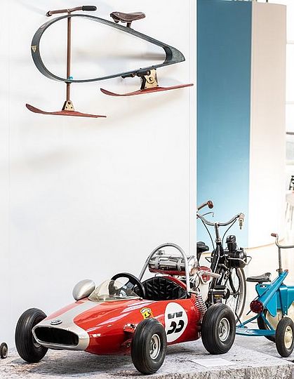 Kinderfahrzeug in Form eines Rennautos.