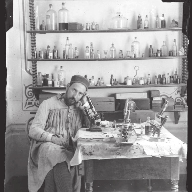 Mann in Labor mit Instrumenten auf dem Tisch und Gläsern im Regal