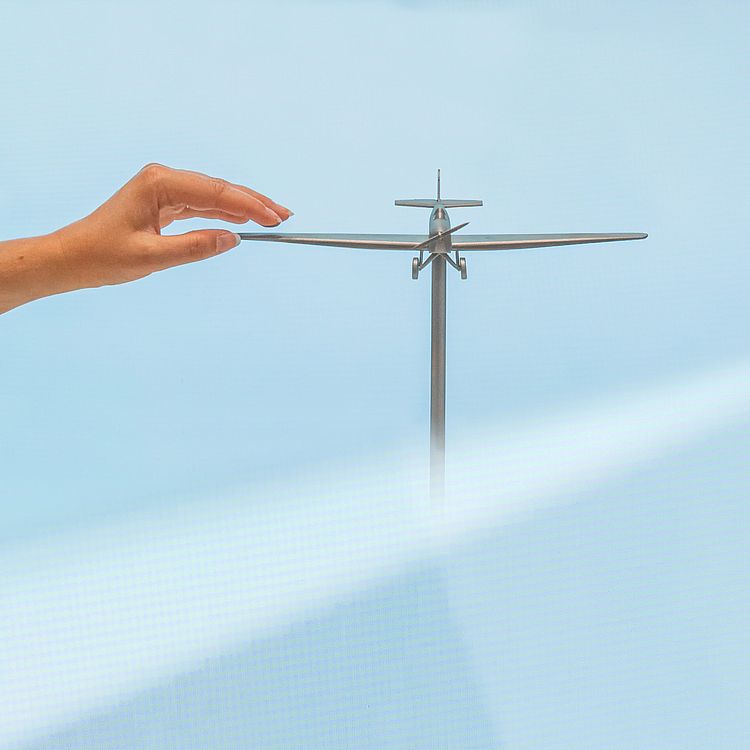 Hand greift an Tastmodell eines Flugzeugs