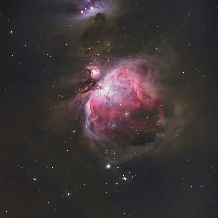 Deep-Field-Aufnahme des Orionnebels (M42) mit leuchtenden rosa- und roten Gaswolken, dunklen Staubfilamenten und zahlreichen weißen Sternpunkten vor dunklem Weltraumhintergrund.