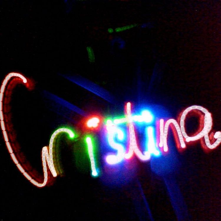 Leuchtender Schriftzug "Christina". Dieser wurde mit verschieden farbigen Lichtquellen in einen dunklen Raum gemalt.