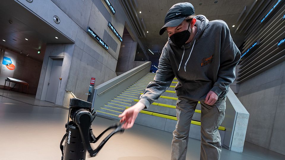 [Translate to English:] Roboterhund Unitree A1 mit Besucher im Deutschen Museum Nürnberg