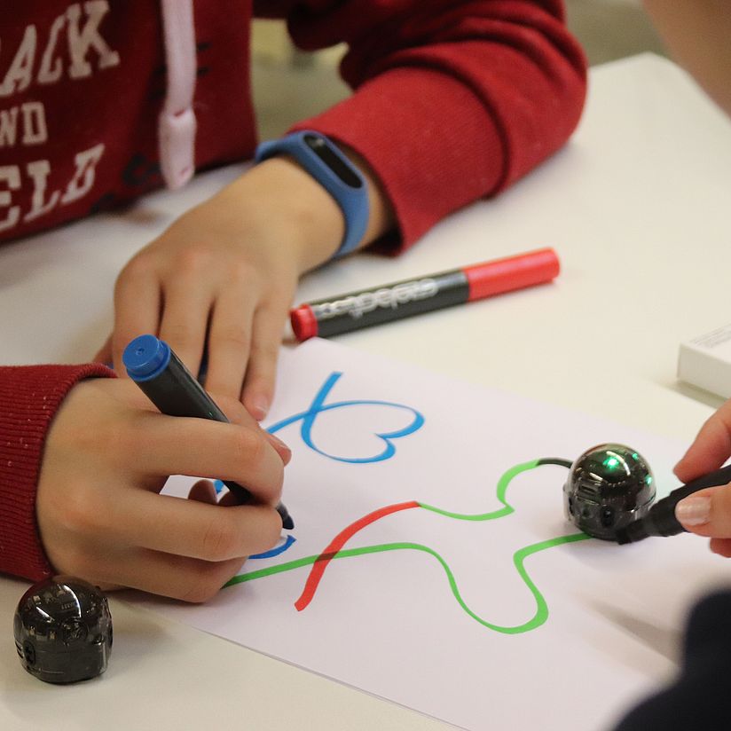 Schulklassenprogramm Programmieren mit Ozobots Schüler beim Programmieren von Ozobots auf Papier.