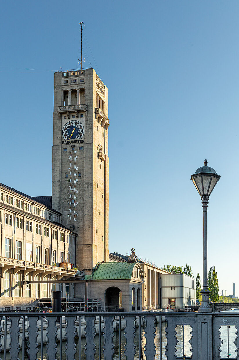 Der Turm an der westlichen Seite des Ausstellungsgebäudes mit einer Fassade auf der das Wetter angezeigt wird.