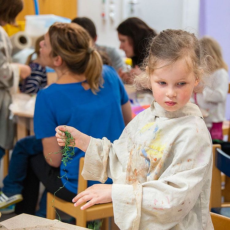 Mädchen bastelt im Workshopbereich des Kinderreichs.