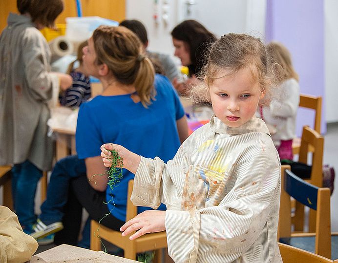 Mädchen bastelt im Workshopbereich des Kinderreichs.