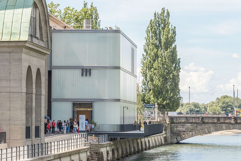 Mehrstöckiges Eingangsgebäude aus Glas an der Corneliusbrücke.