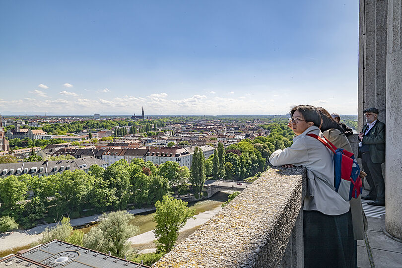 Vier Besucher stehen auf der Plattform und lehnen an der Brüstung.