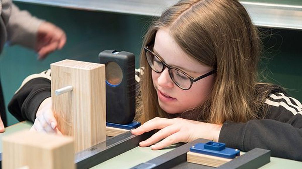 Mädchen baut Experiment auf im Schulklassenprogramm
