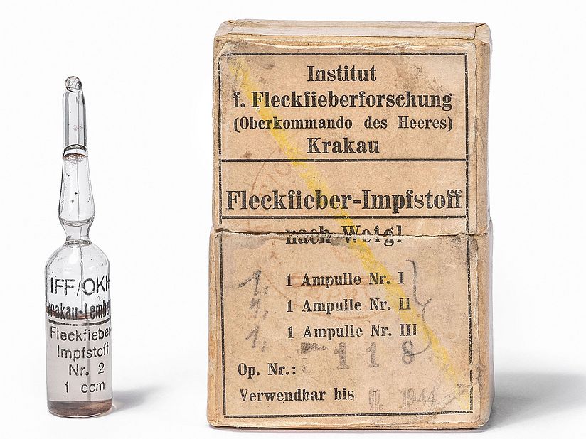 Eine Ampulle und eine Papierpackung.