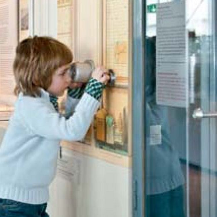 Junge schaut durch ein Guckloch.