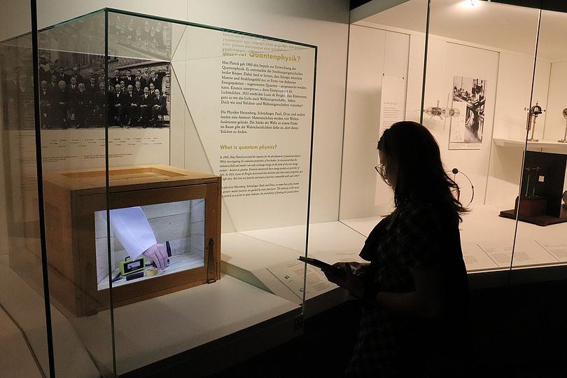 Eine Schülerin steht vor der Vitrine über die Quantenphysik und das Experiment "Schrödingers Katze".