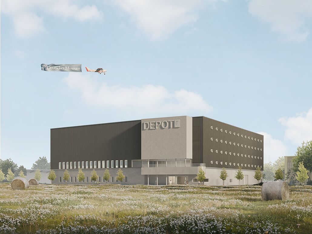 Modernes, blockartiges Depot-Gebäude mit der Aufschrift "DEPOT" auf der Fassade, davor eine blühende Wiese mit Heuballen und jungen Bäumen, im blauen Himmel ein Kleinflugzeug mit Werbebanner "Deutsches Museum".