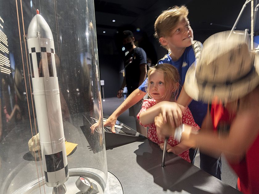 Kinder vor der Mitmachstation "Raketenantrieb" in der Ausstellung Raumfahrt.