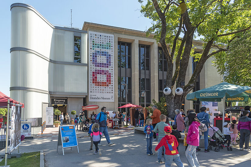 Das Eingangebäude am Museum, Menschen strömen ins Museum.