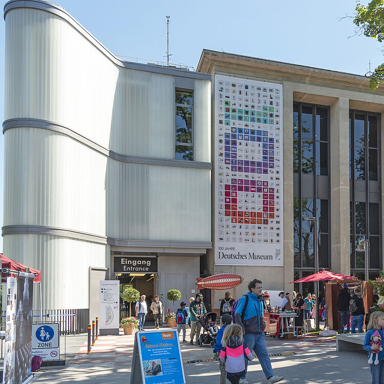 Das Eingangebäude am Museum, Menschen strömen ins Museum.