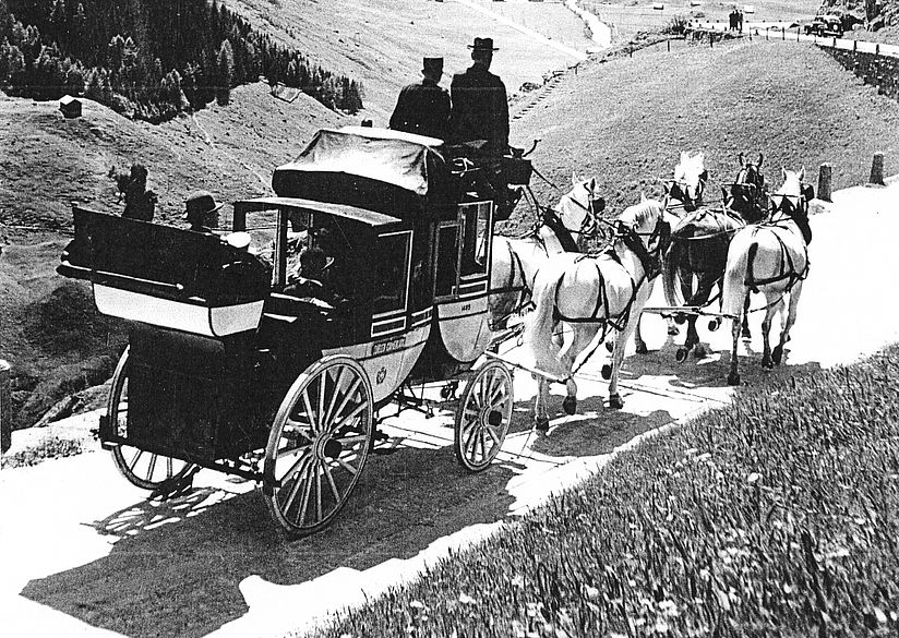 Historische Schwarz-Weiss-Fotografie des Schweizer Alpenpostwagens.