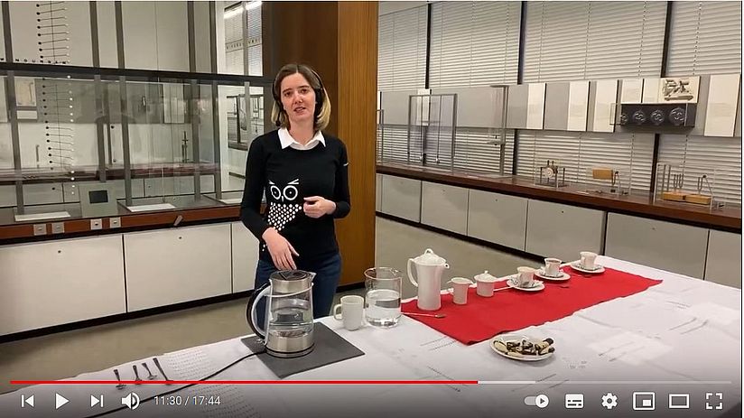 Museum Communicator Anna-Lena erklärt akustische Phänomene in der Kaffeetasse im Livestream aus der Physikabteilung zur digitalen Kaffeepause Screenshot von Livesteam Kaffeepausenführung mit Museum Communicator in der Physikabteilung zu akustischen Effekten an der Kaffeetasse