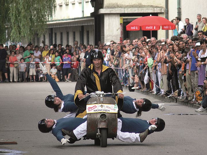 Menschen-Pyramide auf Motorroller.