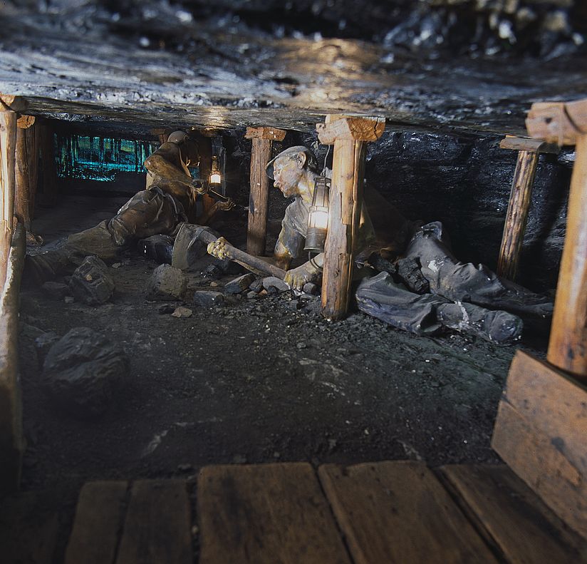 Ausstellung Bergwerk. Pechkohlenabbau in halbsteiler Lagerung. Mann unter Tage arbeitet.
