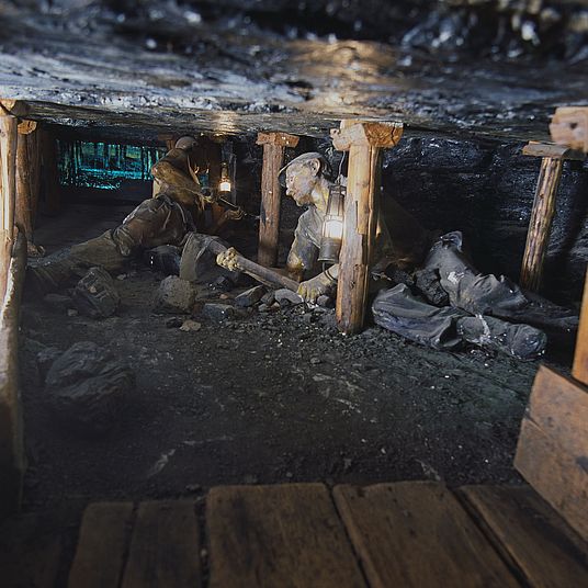 Ausstellung Bergwerk. Pechkohlenabbau in halbsteiler Lagerung. Mann unter Tage arbeitet.