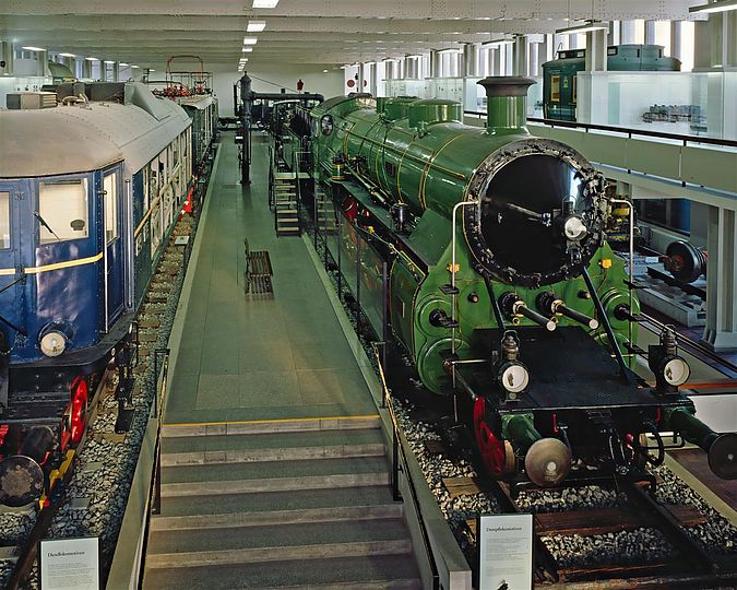 Bahnsteig in der Eisenbahnhalle mit Diesel- und Dampflok.