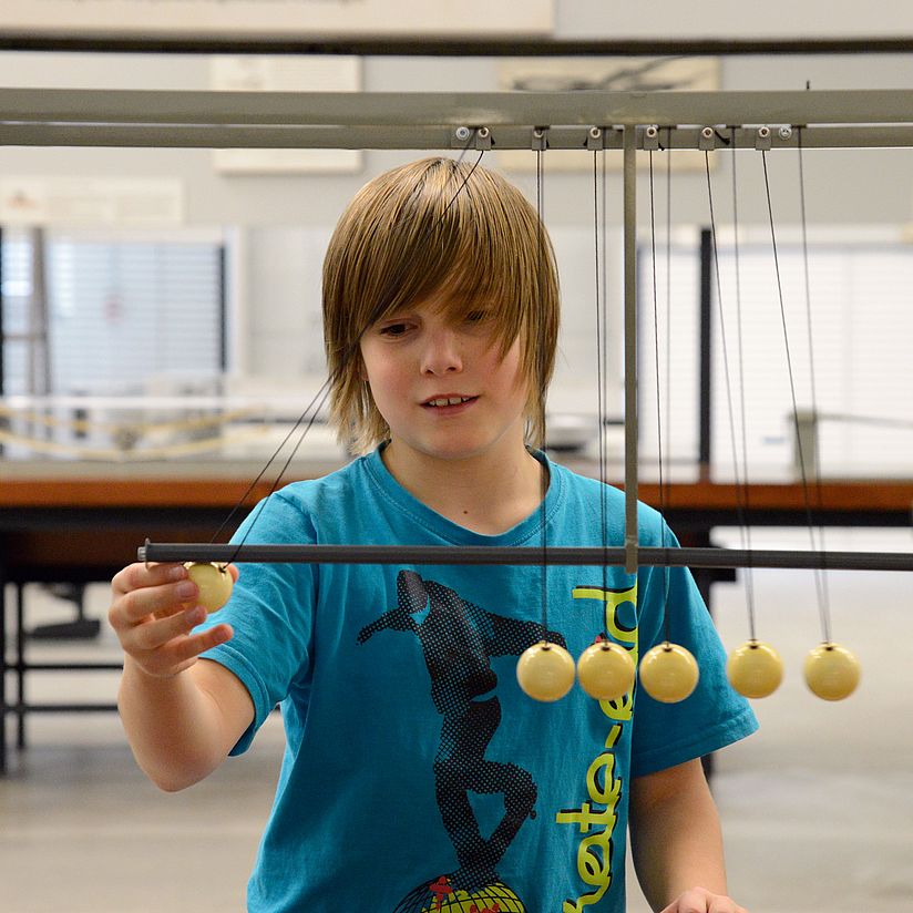 Schulklassenprogramme_Physikausstellung_Kugelpendel_VER4569.jpg Physikausstellung: Schüler vor Kugelpendel