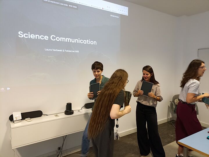 Menschen vor Leinwand mit Präsentation