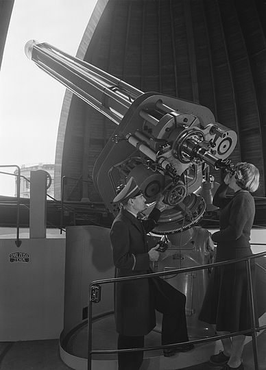 Eine Frau blickt durch den Zeiss-Refraktor in der Wetsternwarte. Das Bild stammt aus dem Jahr 1952.