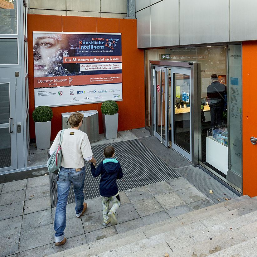 Eingang Deutsches Museum Bonn mit Banner neu Mission KI und Außenlift