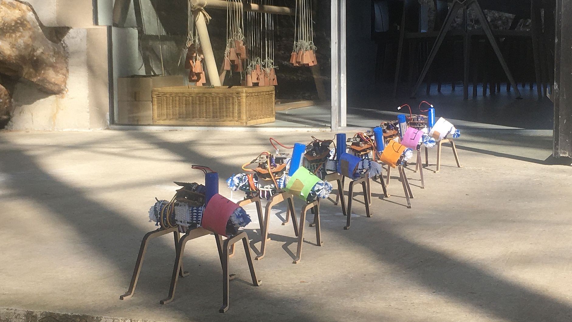 Roboter auf der Terrasse mit dem Gewichtswebstuhl im Hintergrund.