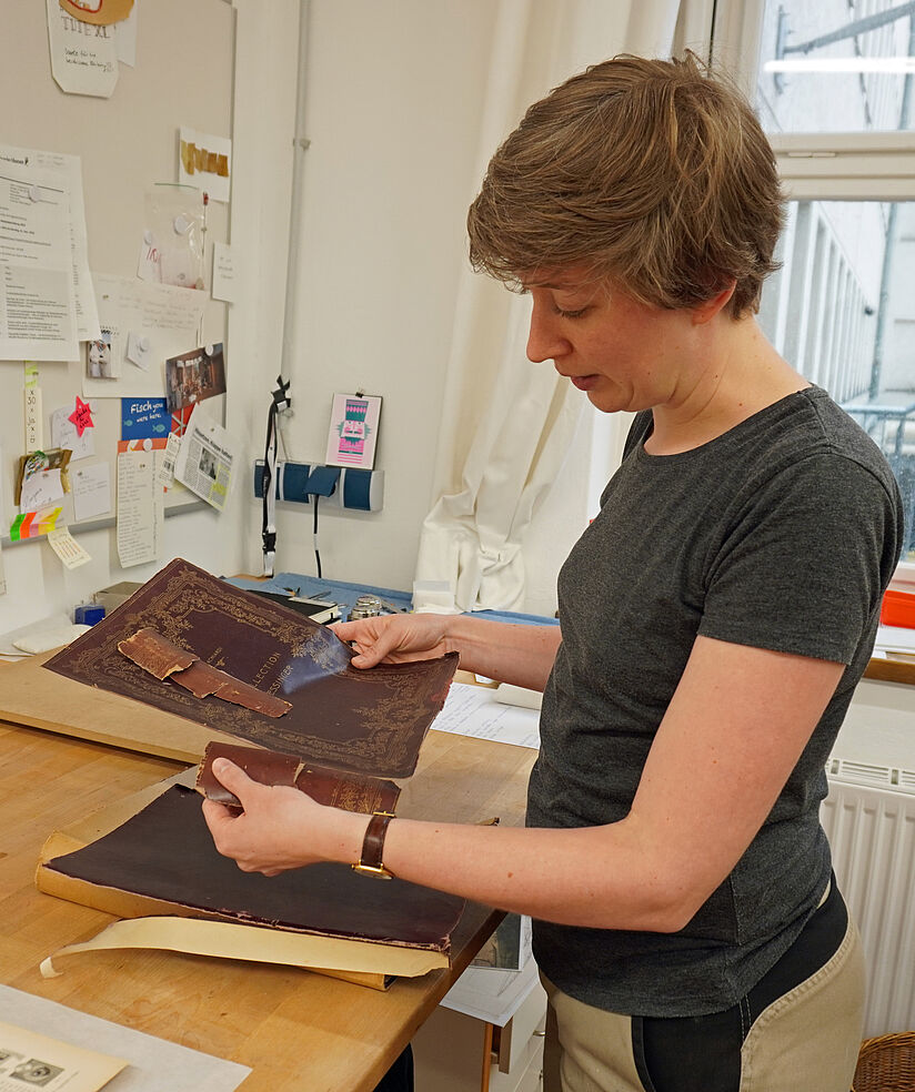 Die Buchbinderin begutachtet ein historisches Dokument