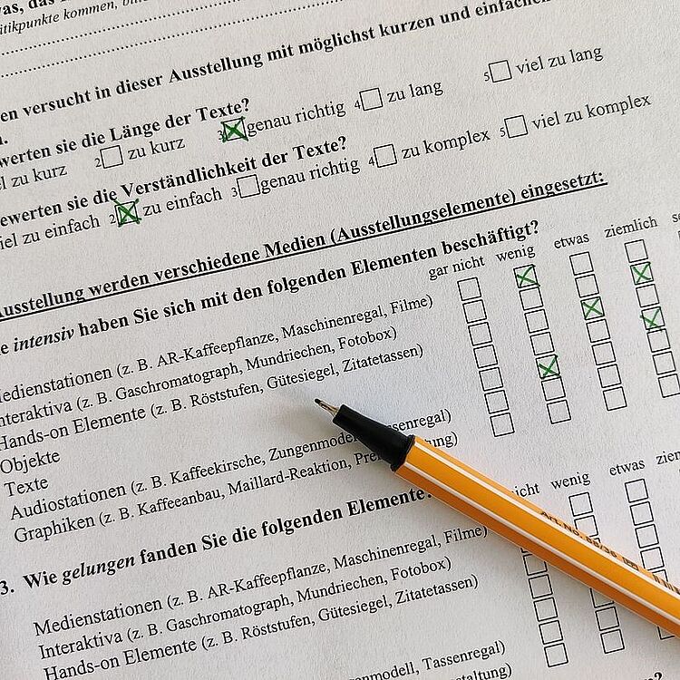 Ein offener Stabilo liegt auf einem halb ausgefüllten Fragebogen.