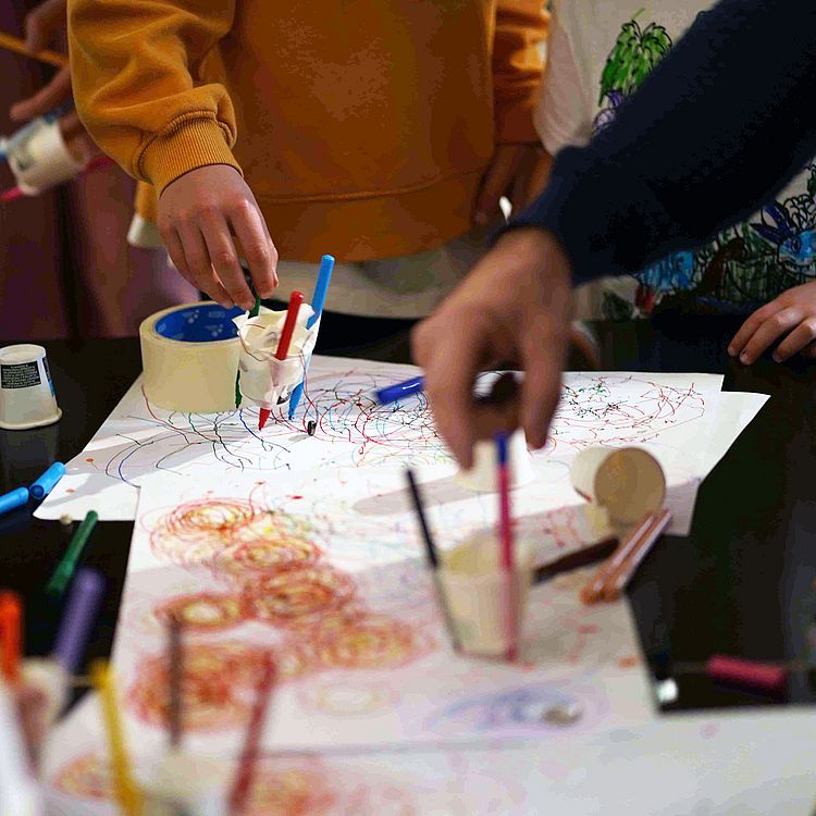 Tinkering-Fortbildung: Personen malen mit Farben auf Papier