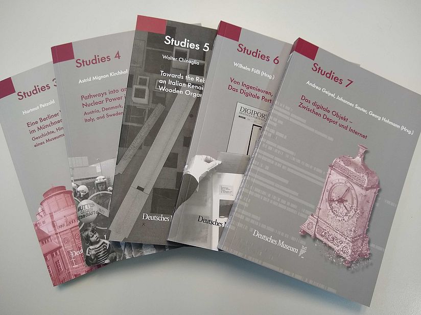 Die Bände 3 bis 7 der Reihe DM Studies, aufgefächert auf einem Tisch
