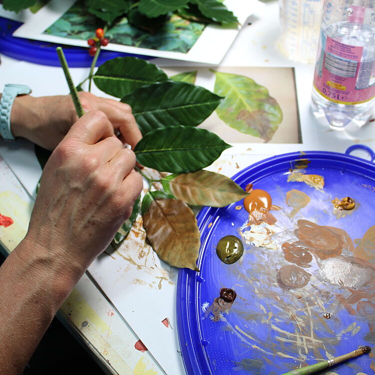 Bemalung von Kaffeepflanzenblättern.