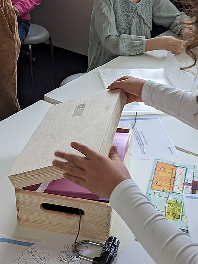 Kinder beim Öffnen einer Kiste. Code geknackt.